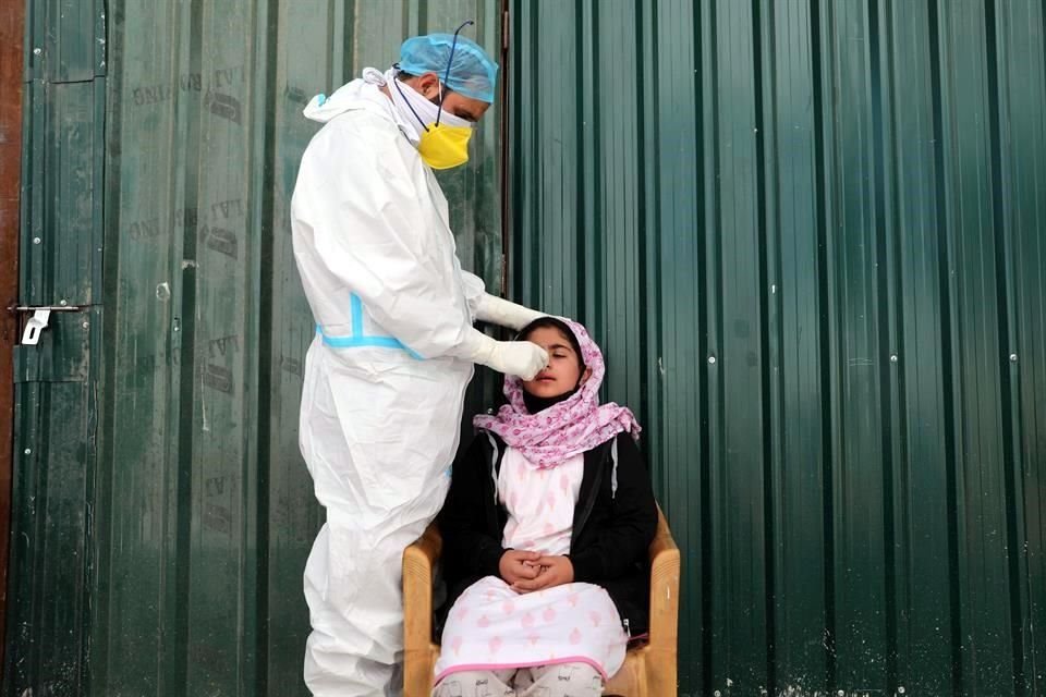 Personal de salud realiza una prueba de Covid-19 a una mujer en Srinagar, India.