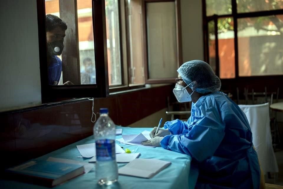 Un trabajador de salud tomo los datos de una persona antes de una prueba de Covid-19 en Nueva Delhi, India.
