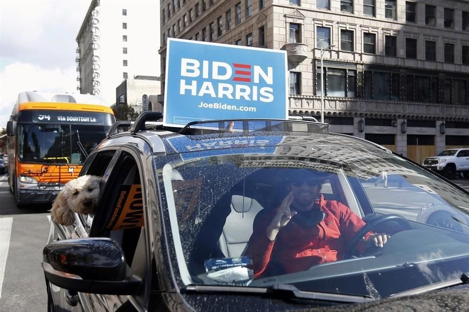 Un automovilista en Los Ángeles muestra un cartel de Biden y Harris.