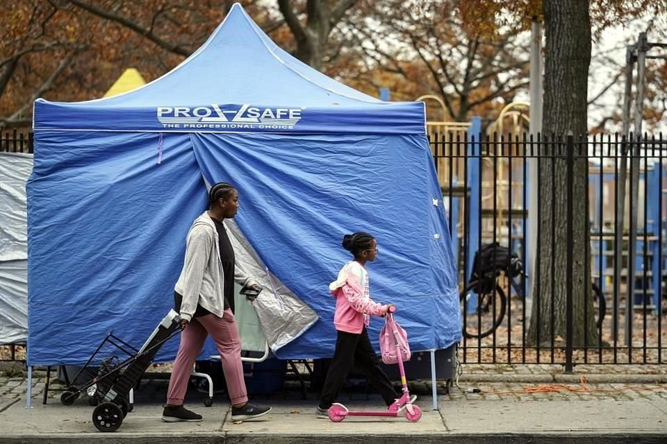 Personas caminan en Nueva York cerca de un puesto móvil de pruebas de Covid-19.