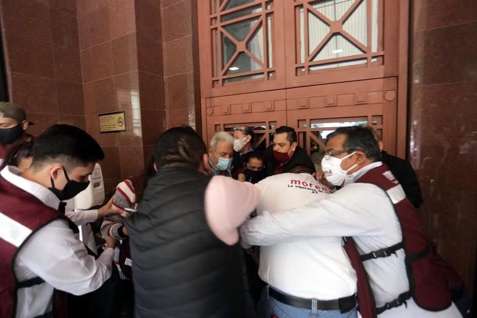 Varios militantes forcejean a la entrada del recinto donde Morena tenía programada su fiesta de unidad.