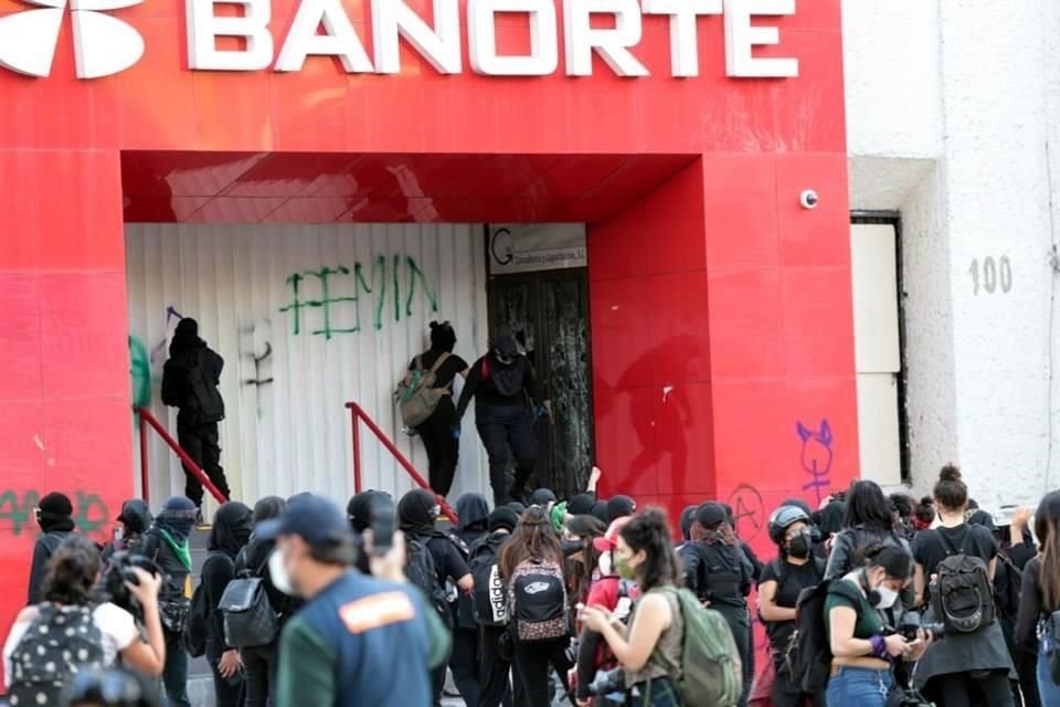 Mujeres encapuchadas realizaron pintas a bancos ubicados sobre Avenida Juárez.