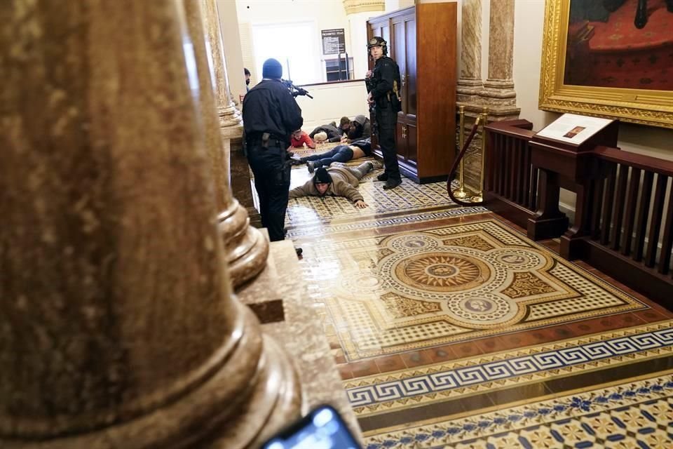 Policías del Capitolio someten a manifestantes protrump.