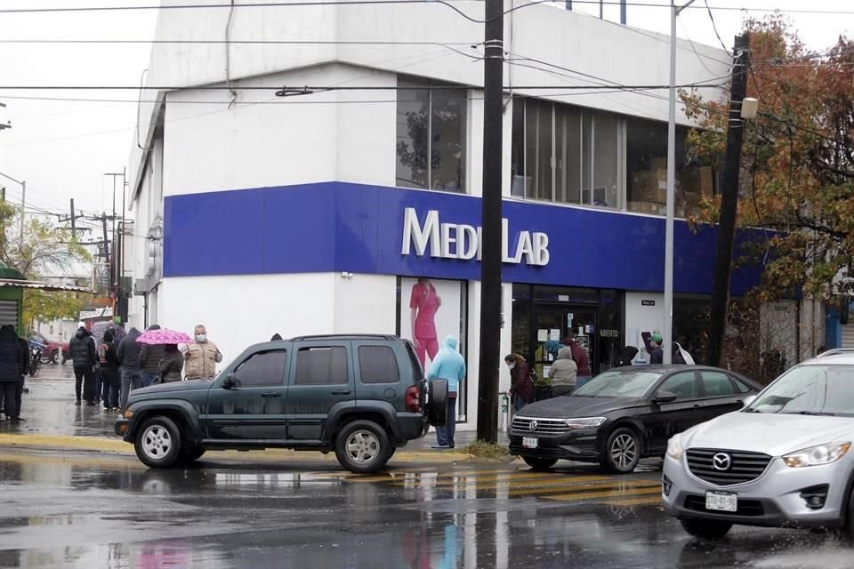 Con todo y lluvia, decenas de personas esperaron afuera de un negocio para recargar tanques de oxígeno.