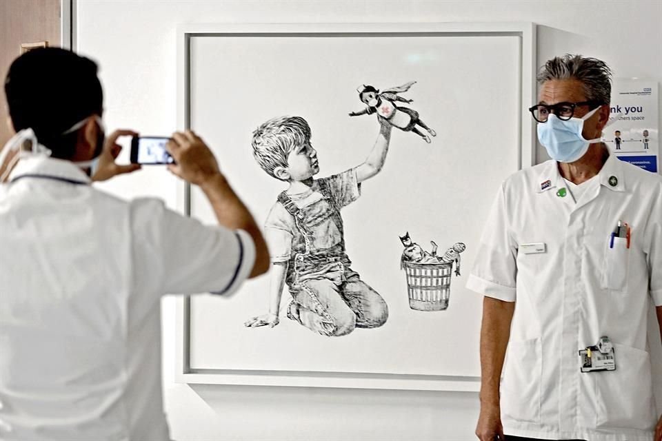Personal médico se toma la foto con 'Game Changer', de Banksy.