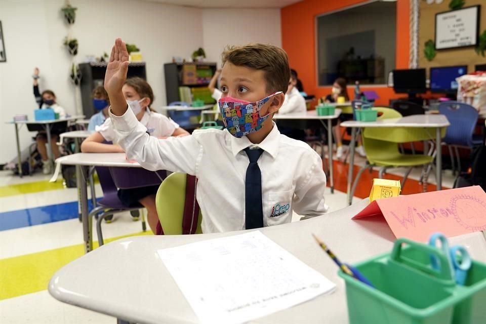 Un alumno de 9 años del Winston Wallace, en Florida, alza la mano durante una clase.