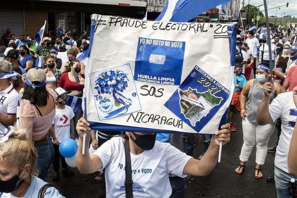 Una mujer en San José, Costa Rica, sostiene una pancarta que reclama un fraude electoral en Nicaragua.