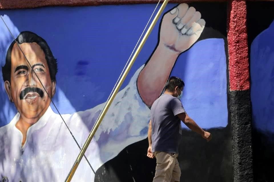 Un hombre camina junto a un mural del Presidente Daniel Ortega.