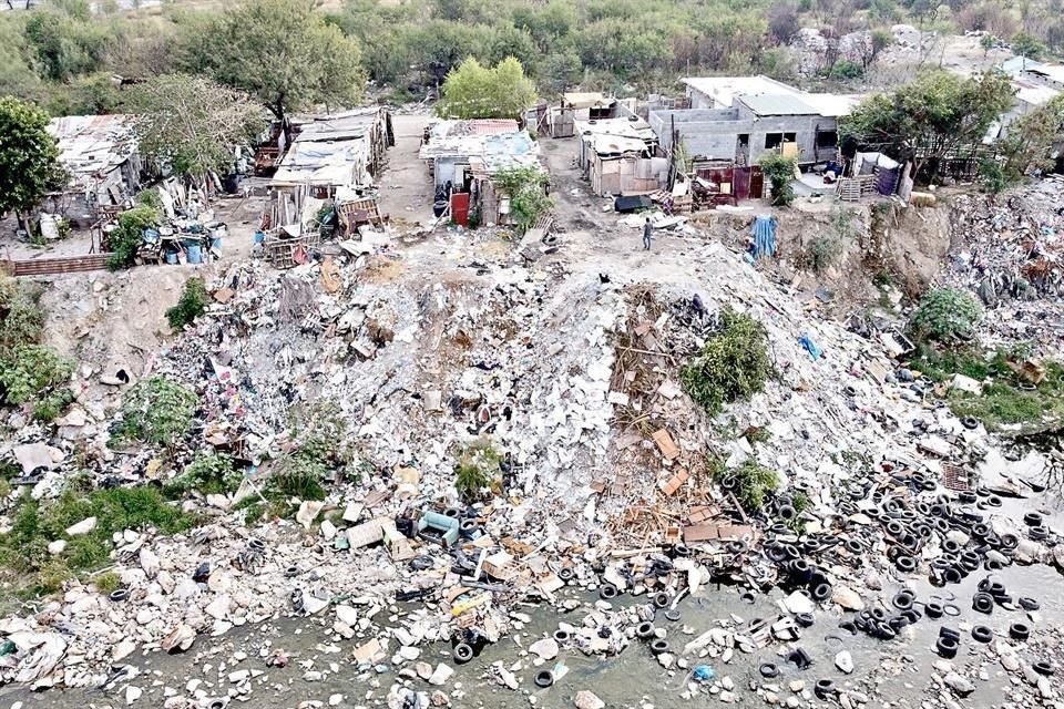 Cientos de familias que viven en el margen del Río Pesquería arrojan diariamente basura hacia el lecho, mientras otra es quemada.