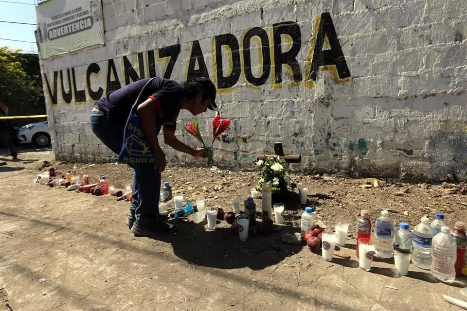 Un hombre coloca flores en el sitio donde se volvó el trailer y murieron decenas de migrantes, en Chiapas.