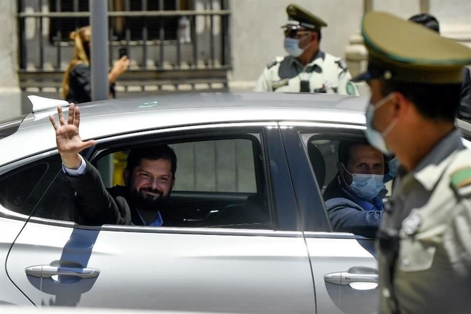 Gabriel Boric saluda a sus simpatizantes este lunes al llegar a La Moneda con el Presidente Sebastián Piñera.