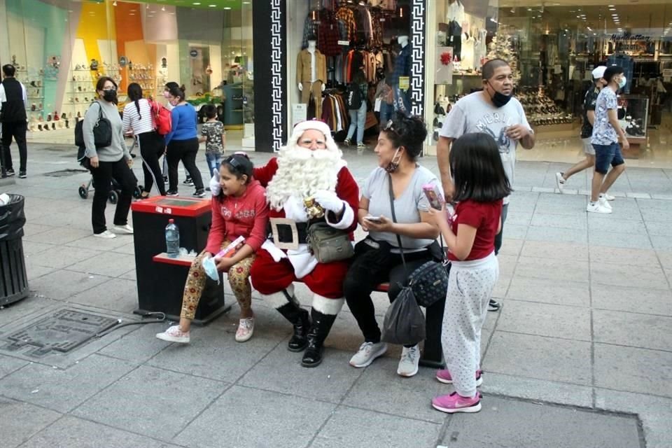 En la Av. Juárez, casi a la altura de 5 de mayo, un Santa Clos mueve efusivamente sus manos, en una tradicional estampa navideña en pleno Centro de Monterrey, donde no falta la música de la temporada.