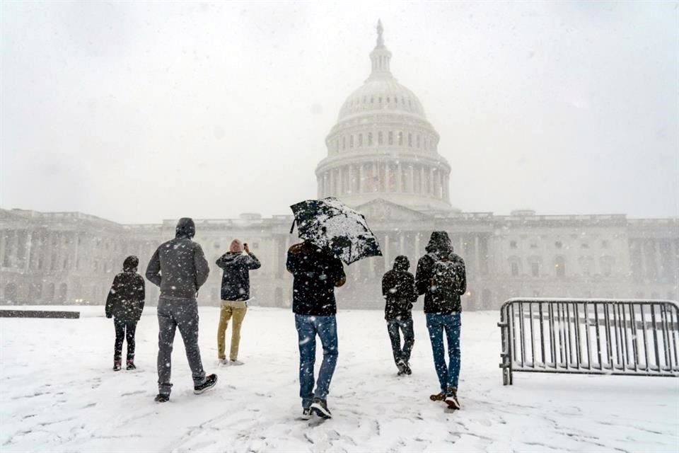 Visitantes de Francia aprecian la vista que dejó la tormenta de nieve cerca del Capitolio.