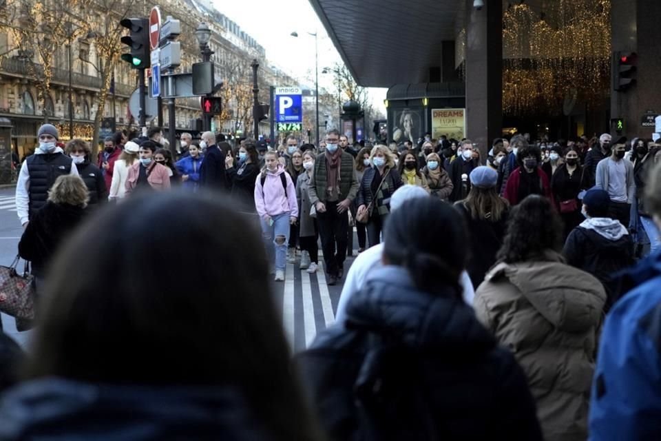 Personas caminan por las calles de Paris, Francia.