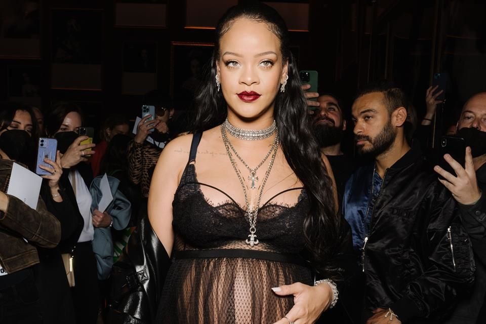 Una de las estrellas invitadas al desfile fue la cantante y actriz Rihanna, quien deslumbró con un vestido transparente, en el que presumía su embarazo, una gabardina negra y una botas de tacón.