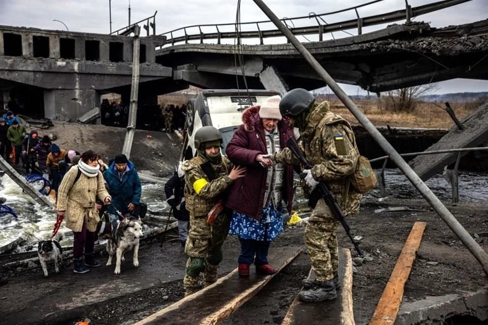 Soldados ayudan a civiles a evacuar la ciudad de Irpin, cerca de Kiev.