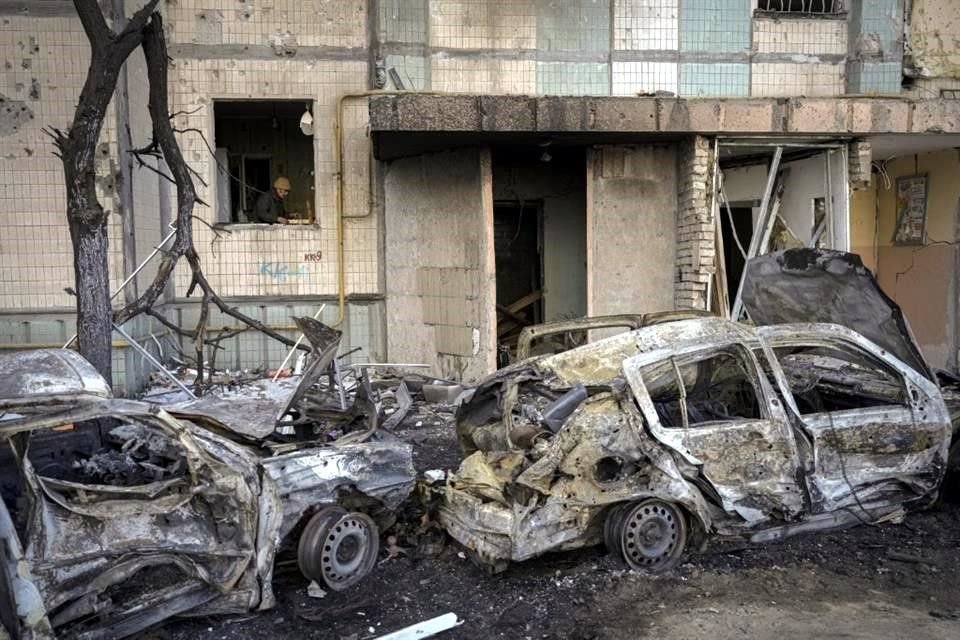 Una mujer limpia el daño en su departamento, un día después de un bombardeo en Kiev.