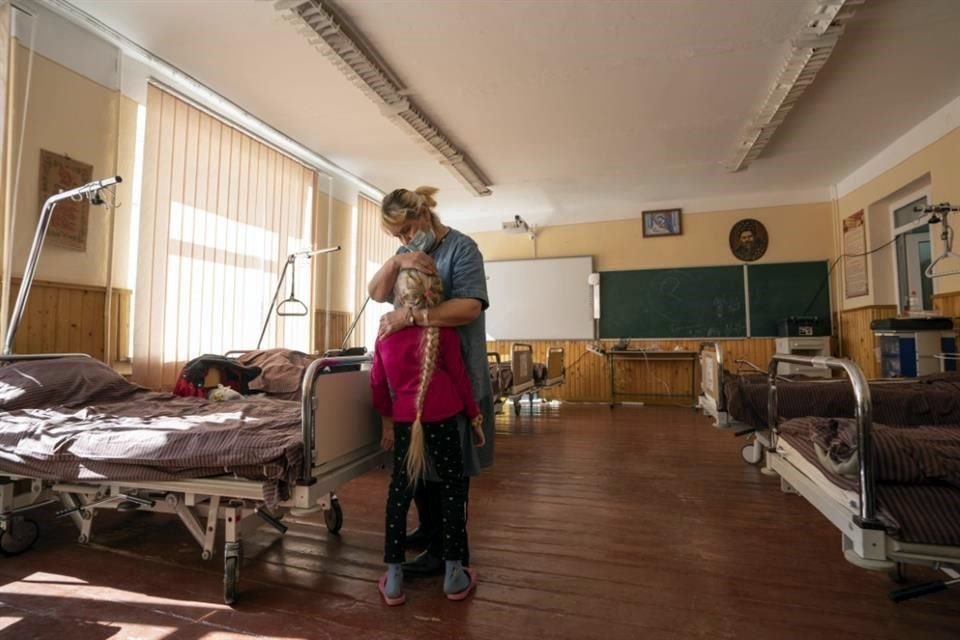 Nadia abraza a su nieta de 10 años, Zlata, quien sufre de una enfermedad cardíaca crónica, y recibe tratamiento en un hospital de campaña en Mostysk, oeste de Ucrania.