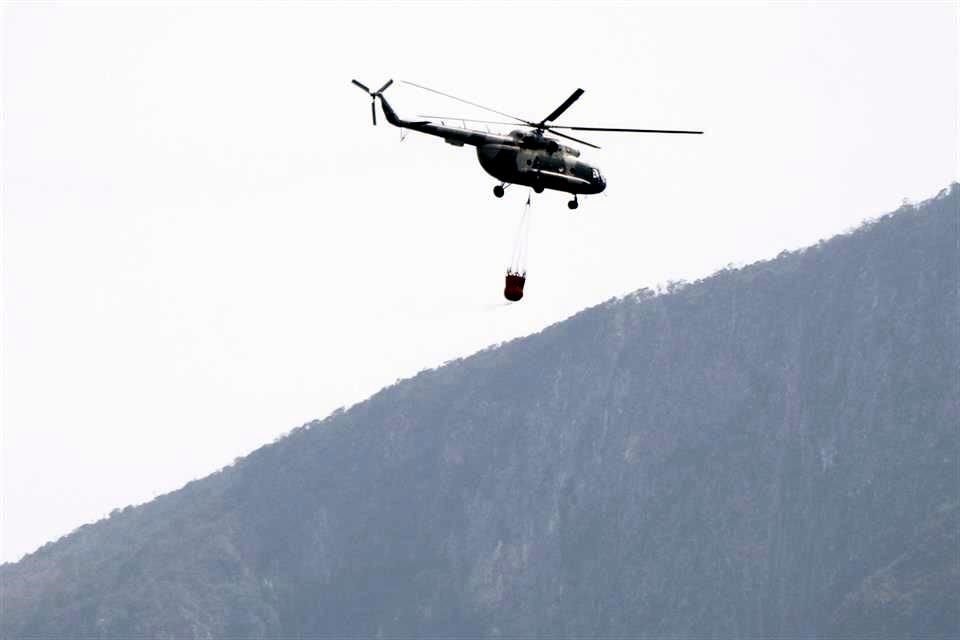 Elementos del Ejército supervisaban las labores por tierra, mientras que por aire dos helicópteros lanzaban cargas de agua.