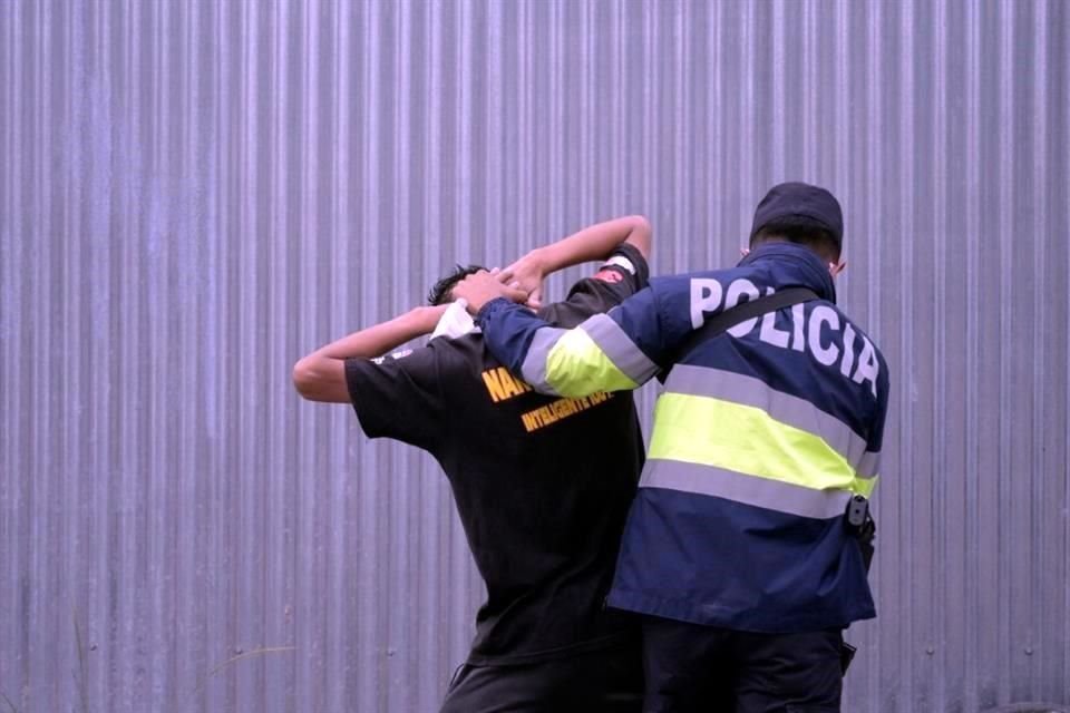 Un policía salvadoreño revisa a un hombre en las calles de la capital durante el estado de excepción.