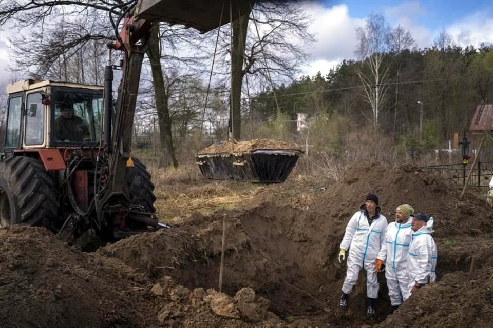 Con ayuda de palas y una excavadora, los voluntarios están sacando los cuerpos que habían sido enterrados en las afueras de Kiev.