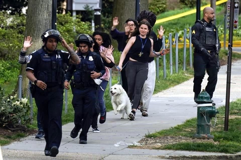 Policías evacuan la zona del tiroteo.