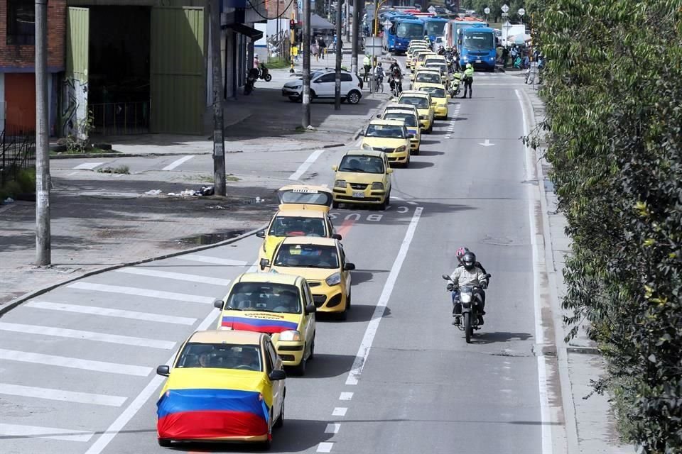 Un grupo de taxistas se moviliza hoy, con banderas de Colombia por las calles de Bogotá.