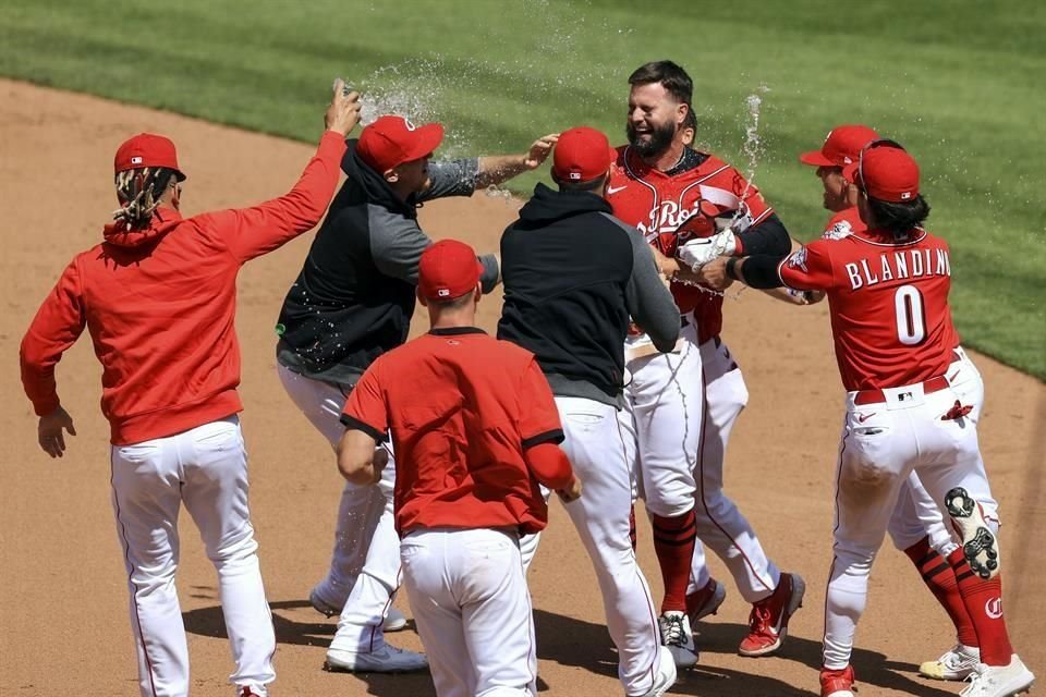 Jesse Winker es felicitado tras conectar el hit del triunfo.