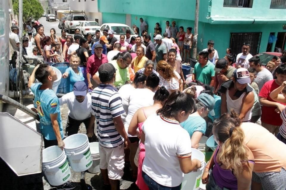 Vecinos del sur de Monterrey rellenan garrafones con agua para sus viviendas. Revolución Proletaria, Colonia