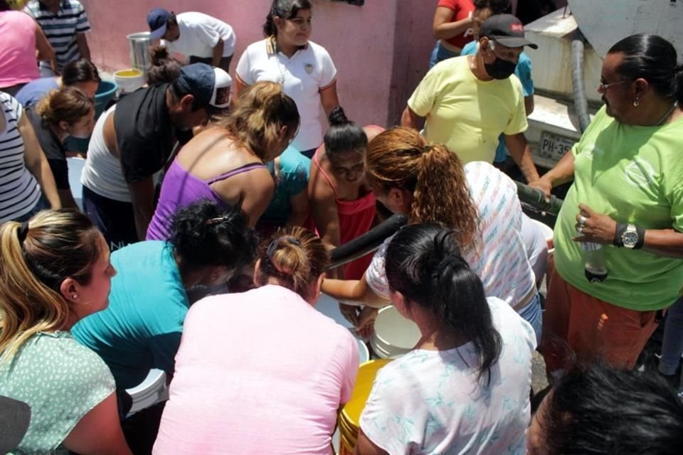 Vecinos del sur de Monterrey rellenan garrafones con agua para sus viviendas. Revolución Proletaria, Colonia