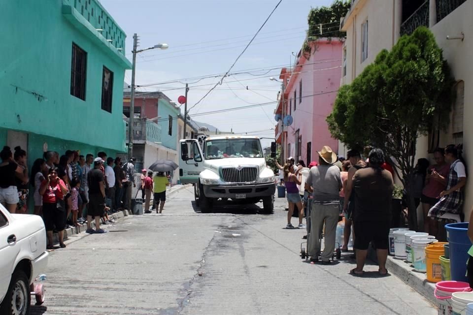Vecinos del sur de Monterrey rellenan garrafones con agua para sus viviendas. Revolución Proletaria, Colonia