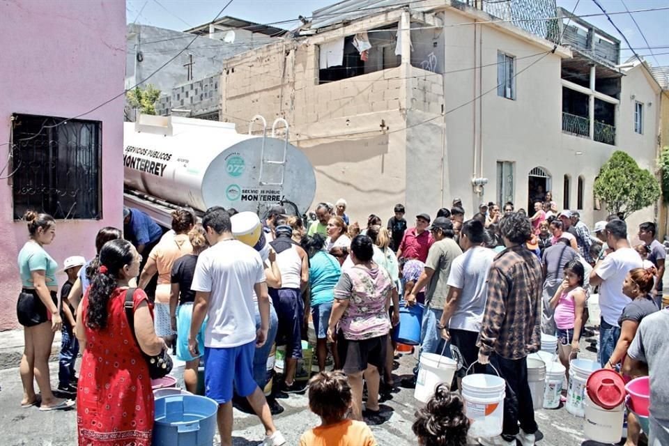 Tras quedarse sin agua en sus casas, vecinos de la Colonia Revolución Proletaria, al sur de Monterrey, esperan la llegada de pipas para llenar sus cubetas.