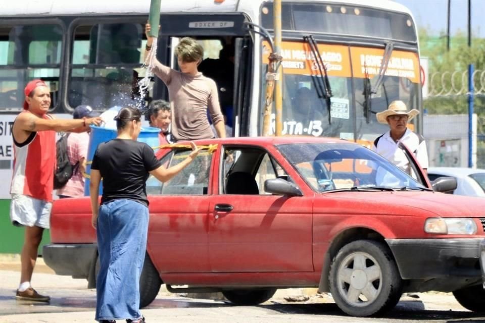 Joel sube un tambo de 200 litros a la parte alta de Lomas de Aztlán, en Escobedo, para que sus vecinos tengan agua.