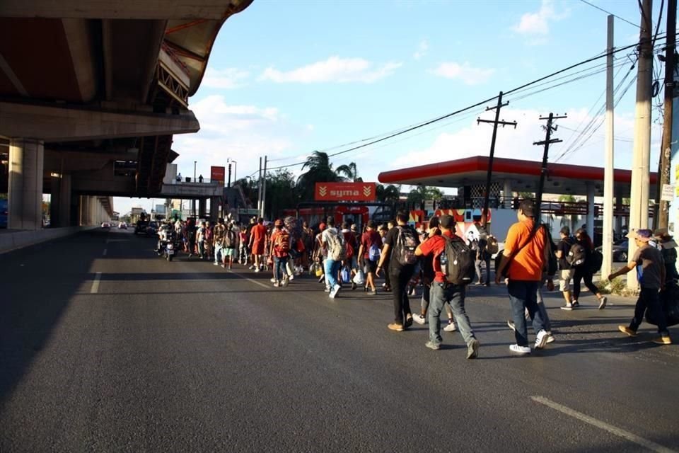 Al no conseguir viajar en autobús, cientos de migrantes salen caminado de la Central y toman Av. Universidad con rumbo a la frontera.