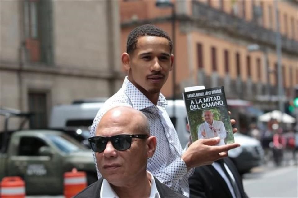 Juan Toscano, único mexicano campeón de la NBA, posa con el libro 'A la mitad del camino', autoría de López Obrador.