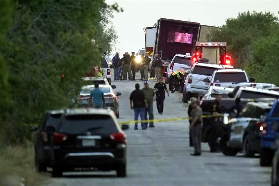 Policías restringen el acceso al tráiler en donde fueron hallados los migrantes muertos.