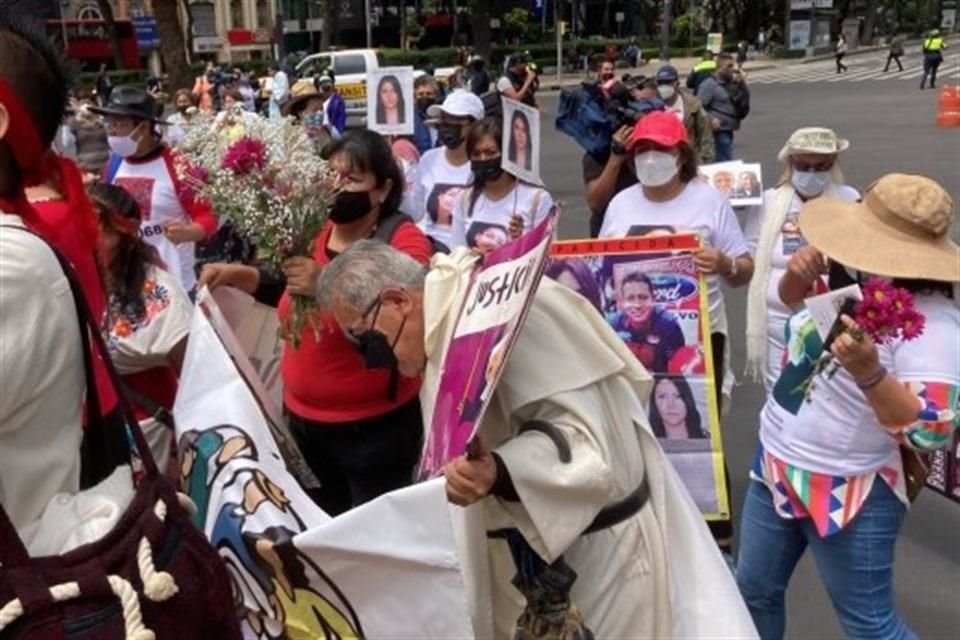 Madres, padres y amigos de personas desaparecidas llevan también cartulinas o mantas con las fotos de sus seres queridos.