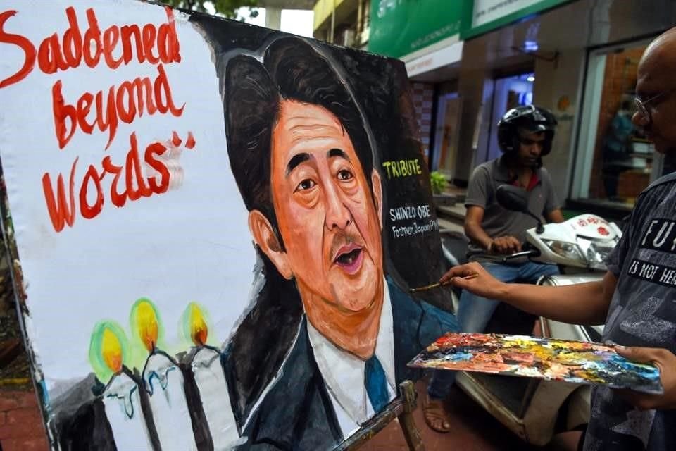 Un artista da los toques finales a una pintura del ex Primer Ministro Japonés, Shinzo Abe, en Bombay.