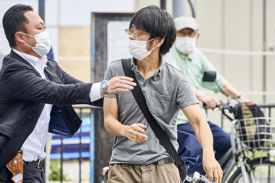 Tetsuya Yamagami, izquierda, con un arma, es detenido en Nara, Japón.