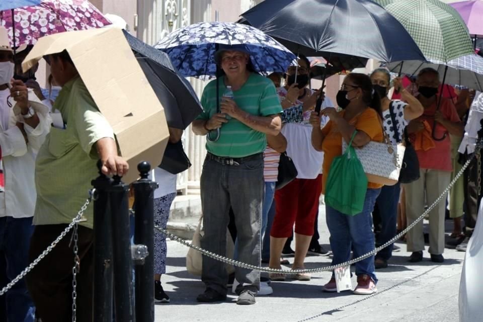 Aunque la mayoría trae sombrilla y sillas plegables, hay personas que se cubren del sol con cartones.