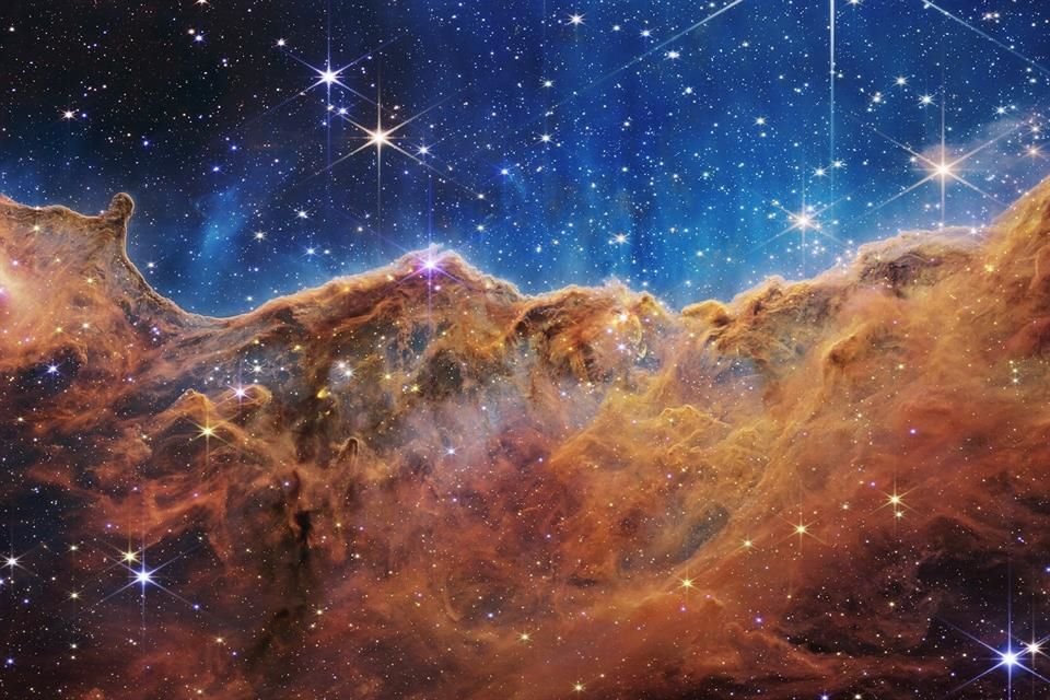 Imagen tomada por el telescopio James Webb de  los 'acantilados cósmicos' de la nebulosa de Carina, en donde se lograron ver nuevas estrellas en la nube de polvo.