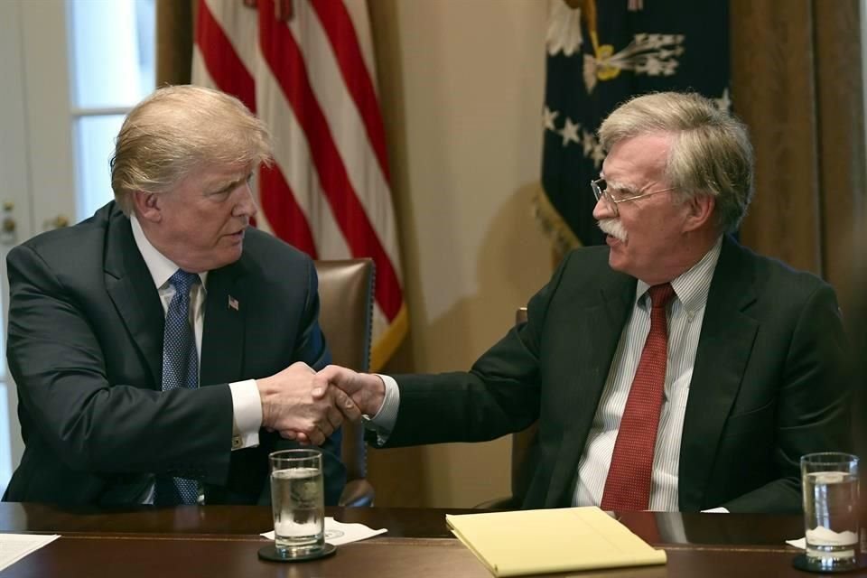 El ex Presidente Donald Trump se da la mano con su entonces asesor de seguridad John Bolton.