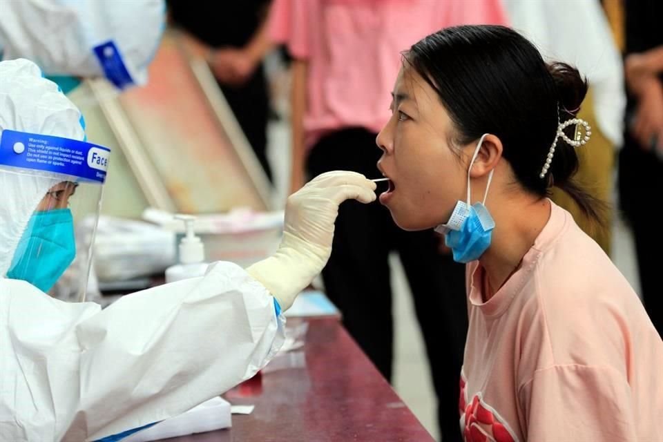 Personal de salud toma muestras para pruebas de Covid-19 en Zhangye, China.