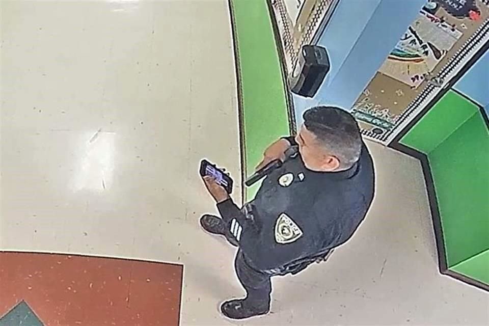 El agente Rubén Ruiz revisa su teléfono durante el tiroteo en la Escuela Primara Robb de Uvalde, Texas.