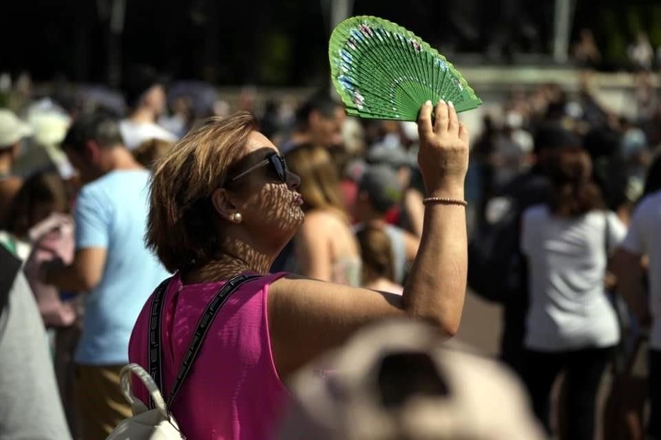 Una mujer se cubre del sol durante un evento cerca del Palacio de Buckingham, en Londres.