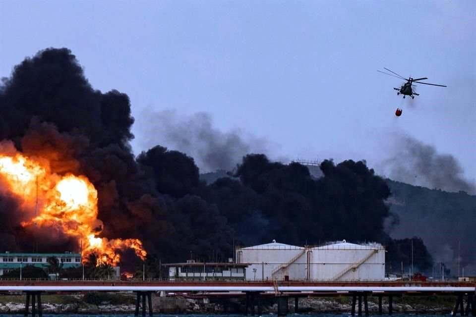 Un helicóptero de bomberos arroja agua sobre un masivo incendio en un depósito de combustible en Matanzas, Cuba.