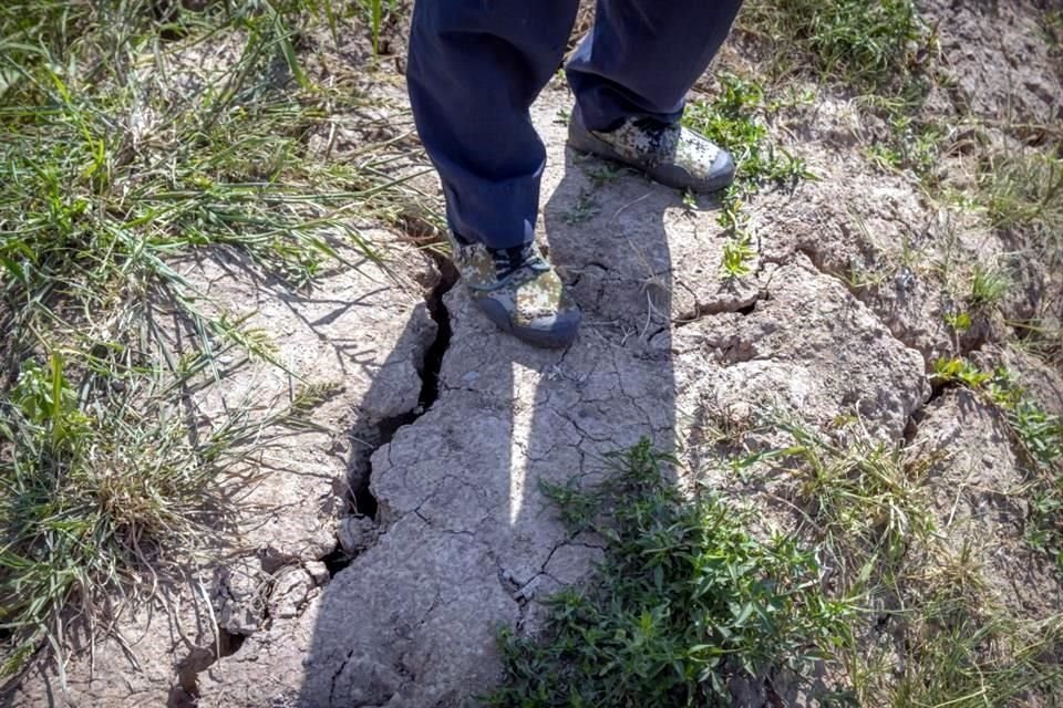 Un agricultor se para sobre una grieta profunda en lodo seco en campos de arroz en las afueras de Chongqing, China, este domingo.