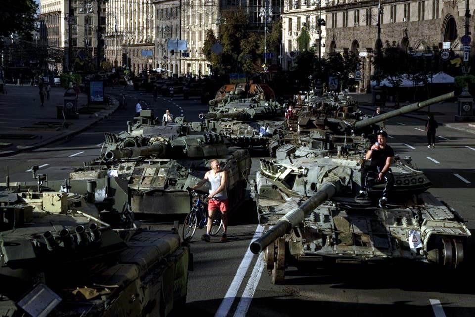 Personas caminan por el centro de Kiev entre tanques rusos destruidos que fueron colocados en exhibición.