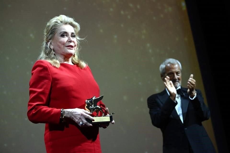 El presidente de La Mostra, Roberto Cicutto, ovaciona a la actriz francesa Catherine Deneuve luego de otorgarle un premio especial por su trayectoria.