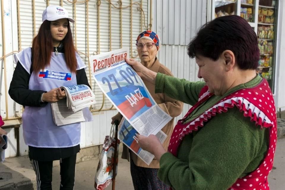 Una voluntaria en Lugansk reparte periódicos sobre los referéndums a los residentes de la región ocupada.